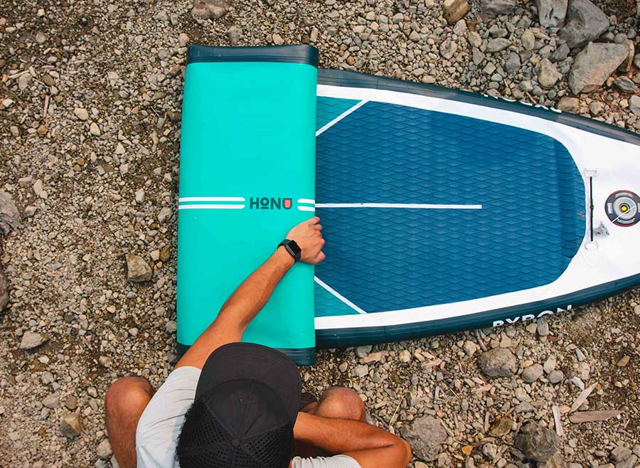 Un-rolling a paddleboard next to USA Lake